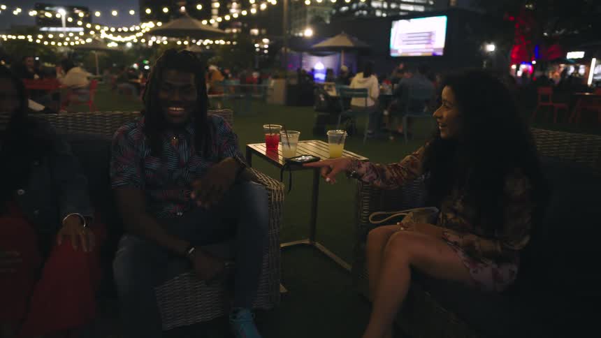 Friends at a bar sitting talking at night