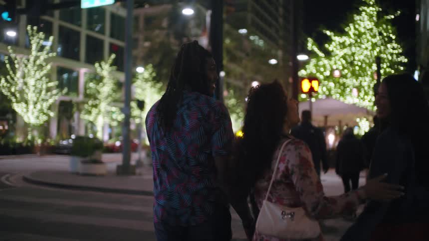 People walking through the streets of a city at night