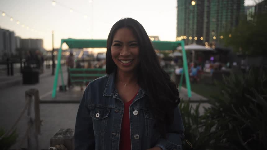 Portrait of a smiling woman while standing in an outdoor bar setting