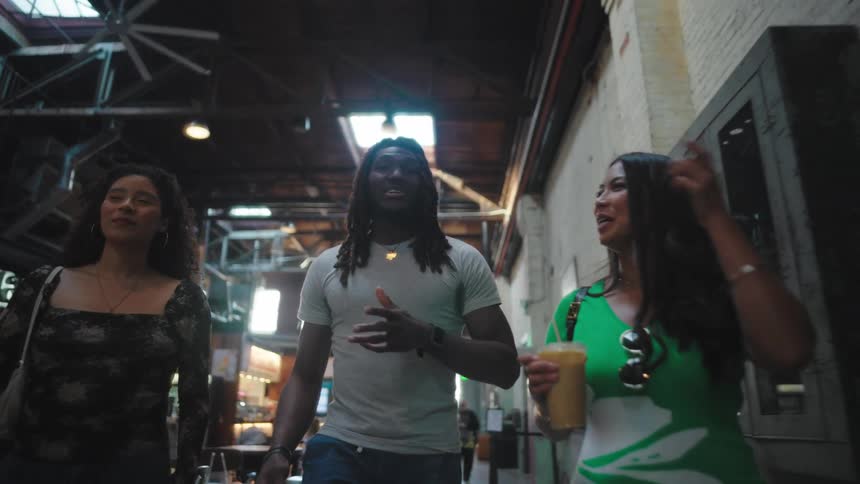 Man and two women walking in an indoor space