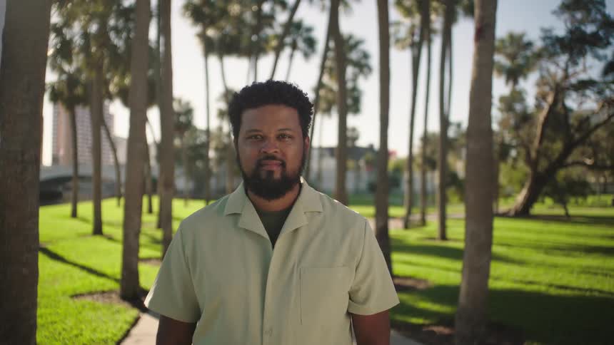 Portrait of a man in a park with trees during the day