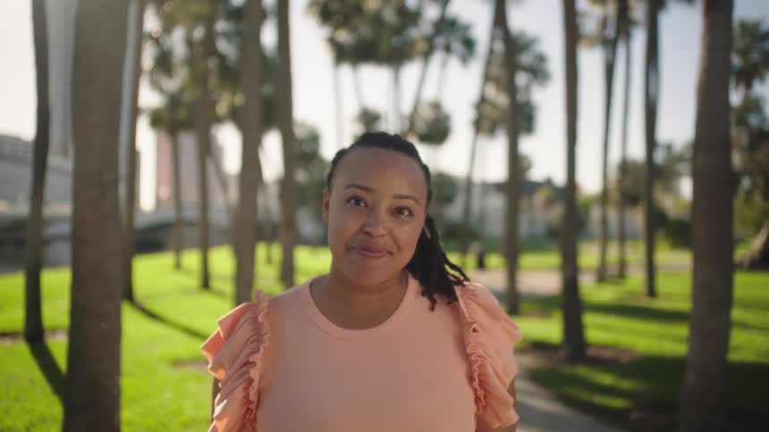 Woman in a park with palm trees with happy expression