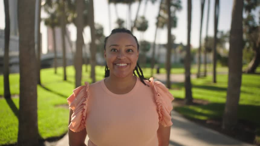 Smiling woman standing in a square with palm trees