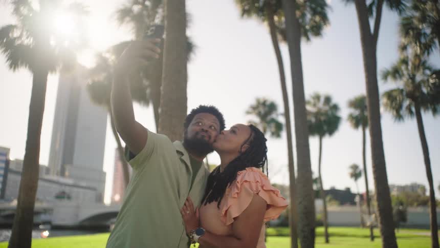 Man and woman taking selfie outdoors in the city