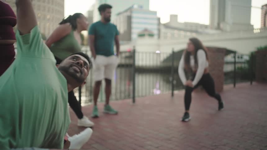 Small group of men and women stretching outdoors