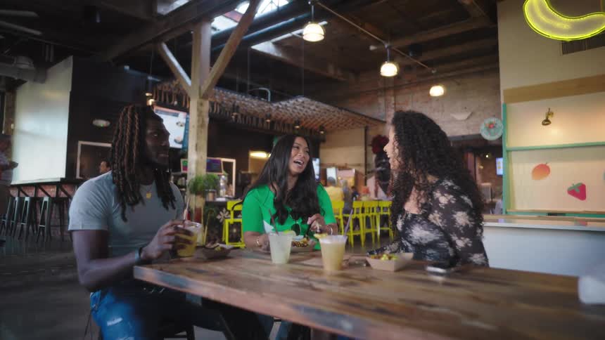 Friends smile and talk while sitting in a restaurant for a meal during the daytime