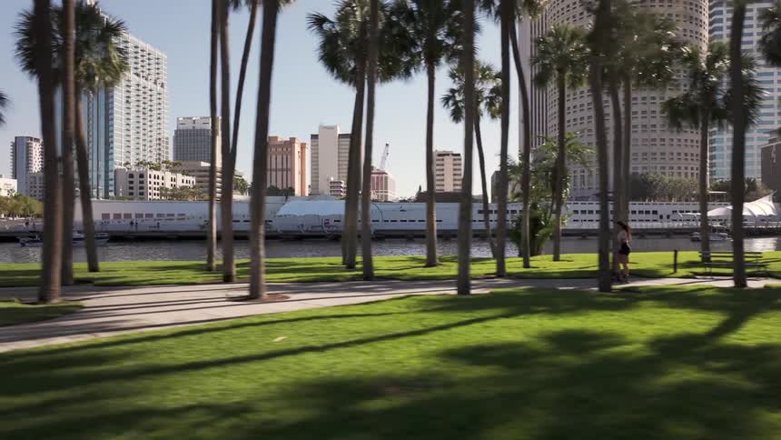 Woman rollerblading on a path at a waterfront park in the city