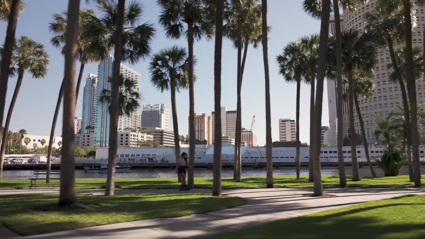 Woman rollerblading on a path at a waterfront park in the city