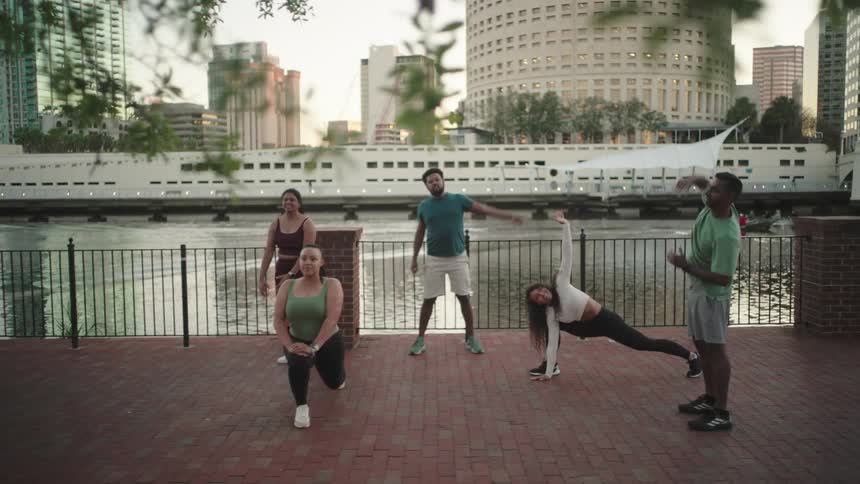A group of people are stretching by the water