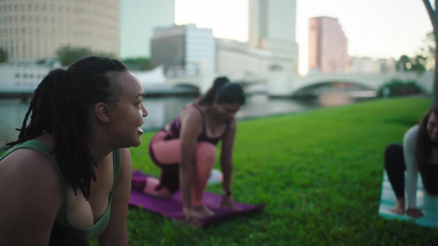 Women are talking while doing yoga on the grass