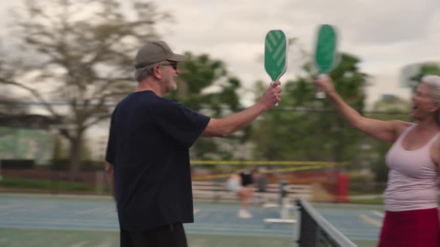 Two players slap their rackets together during a game