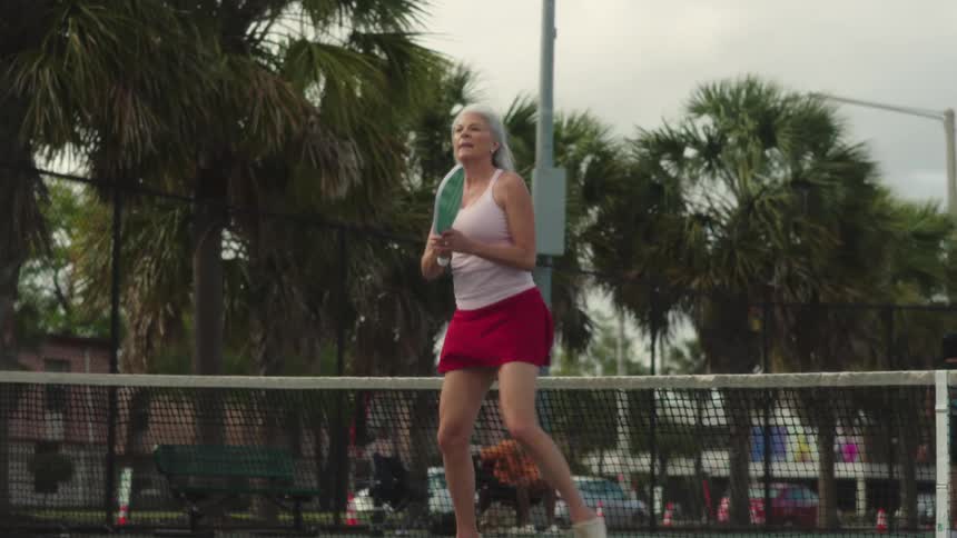 Woman on an outdoor court playing pickleball