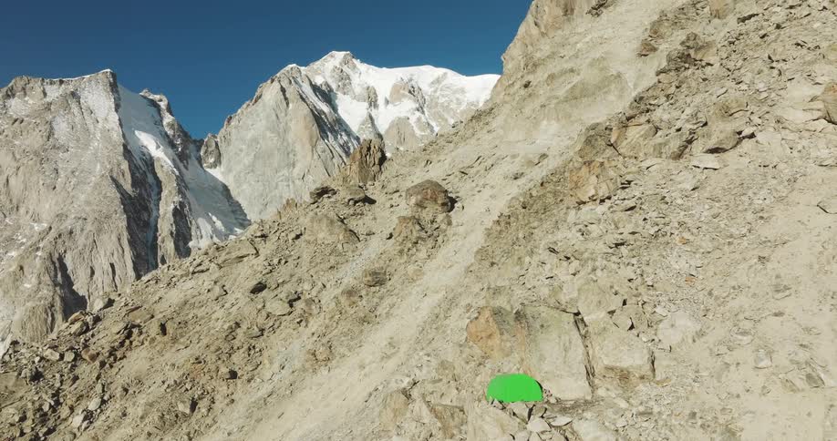 Aerial panorama of a green tent on a mountain with cliffs