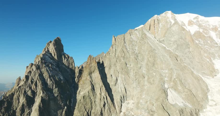 Aerial view of mountains with cliffs against a clear blue sky