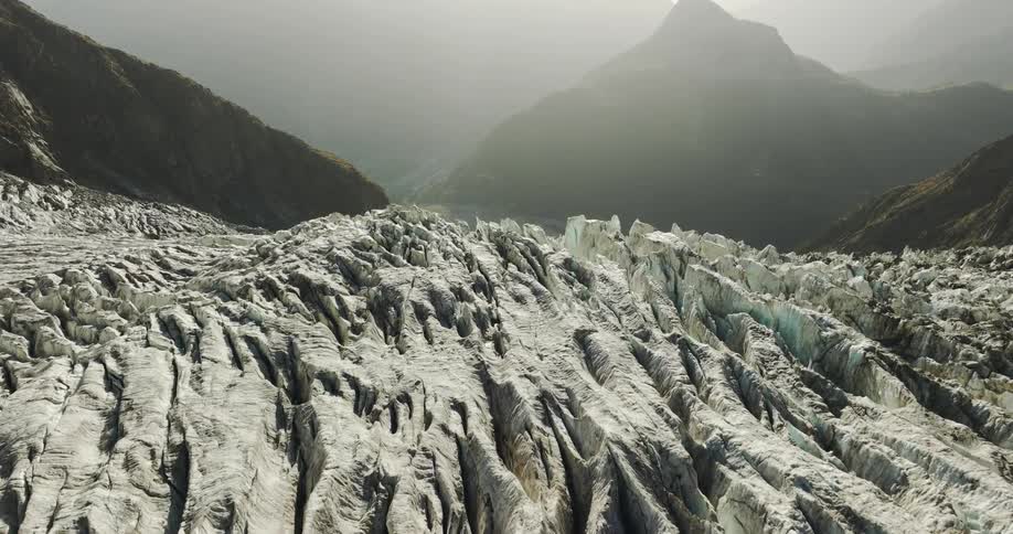 Aerial view of frozen crevasses and mountain cliffs