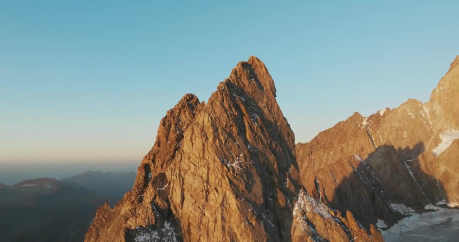 Towering mountains with cliffs seen at sunrise