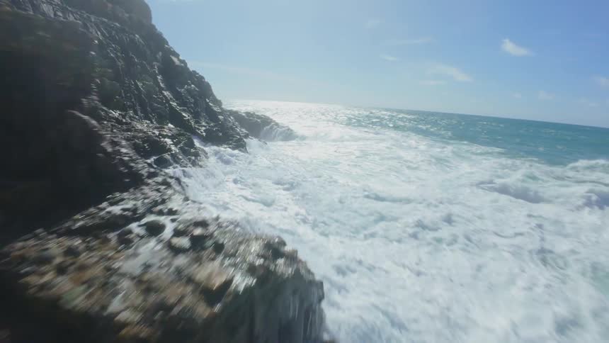 Aerial view of a rocky coastline on the edge of a turbulent sea