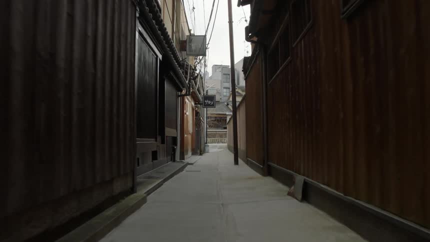 People walk on a sidewalk in a town