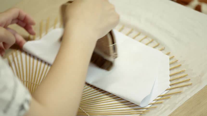 A person applies some glue to a piece of paper