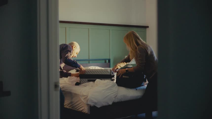 A footage of a man and a woman packing their luggage in a hurry