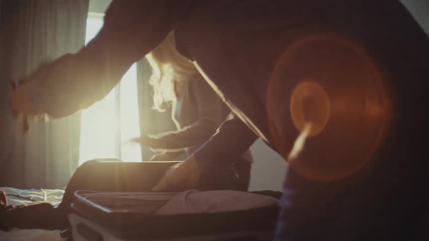 A footage of a man and a woman packing their luggage