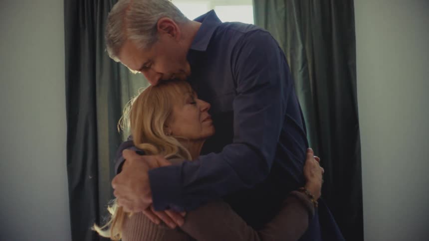 A husband hugs his wife