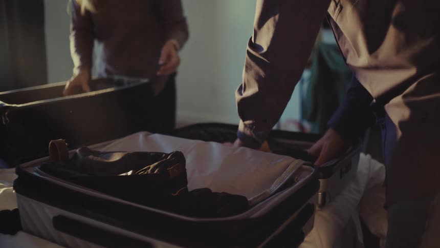 A footage of a man and a woman packing their luggage
