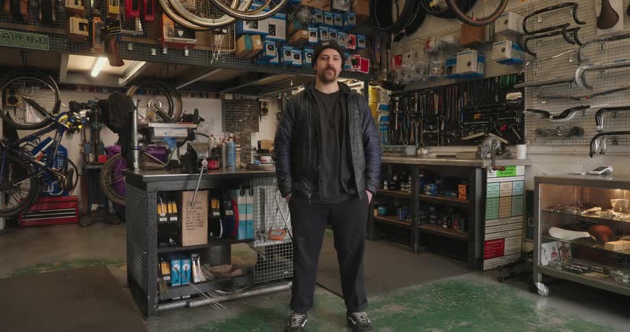 A man is standing in the middle of the bike shop