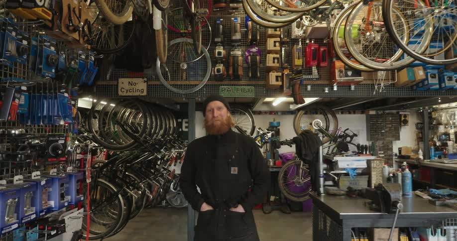 A man smiles in the bike shop