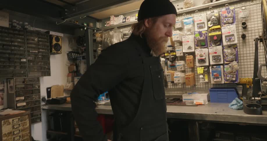A footage of a man putting on a black apron in a store