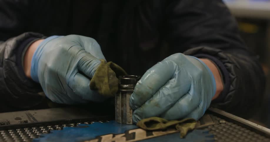 Mechanic wearing gloves working on a bicycle cylinder
