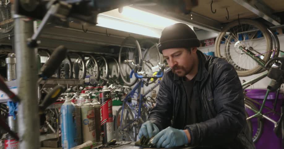 Man in a cap working on a bicycle cylinder