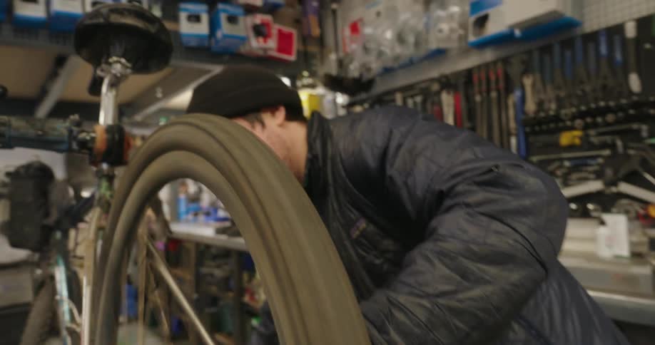 Man in a cap working on repairing a bicycle