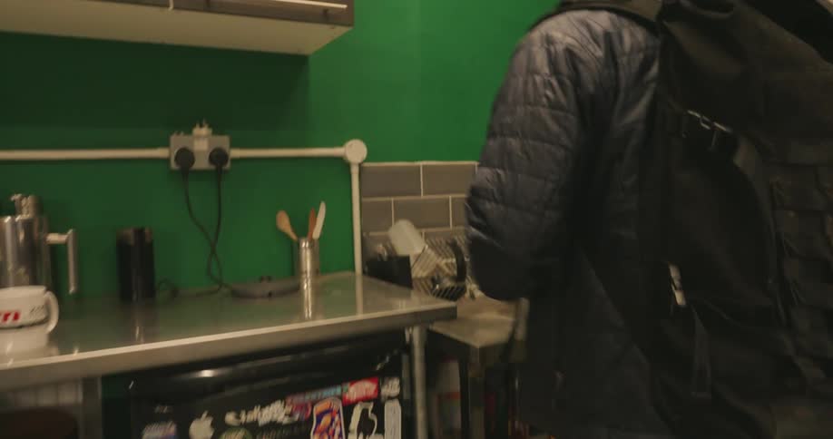 A worker enters the bike shop and fills a kettle with water