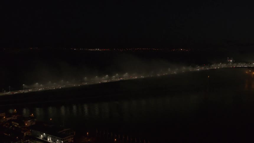 Aerial view of a metropolis highway at night with vehicle traffic and seaside