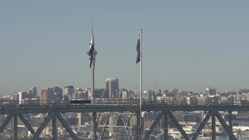 Aerial view of two australian flags in the foreground and a modern metropolis in the background