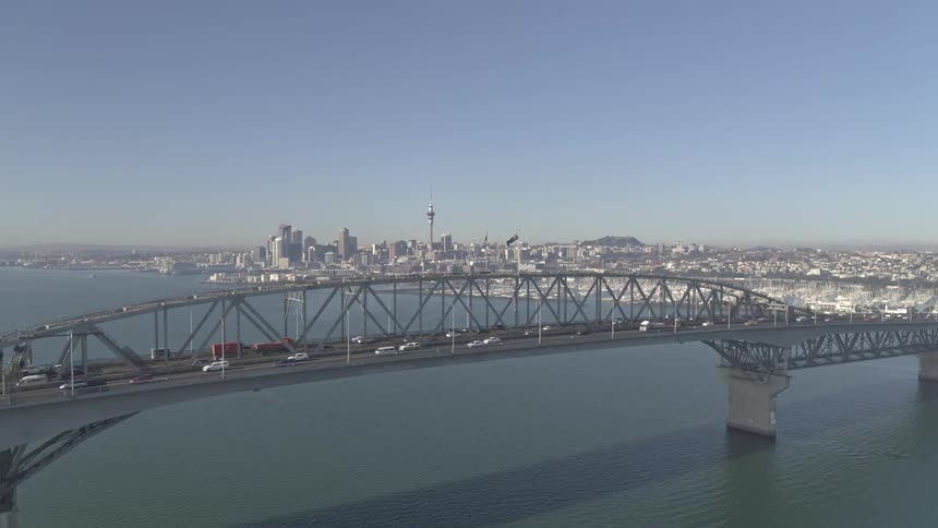 The long bridge has heavy traffic on a sunny day