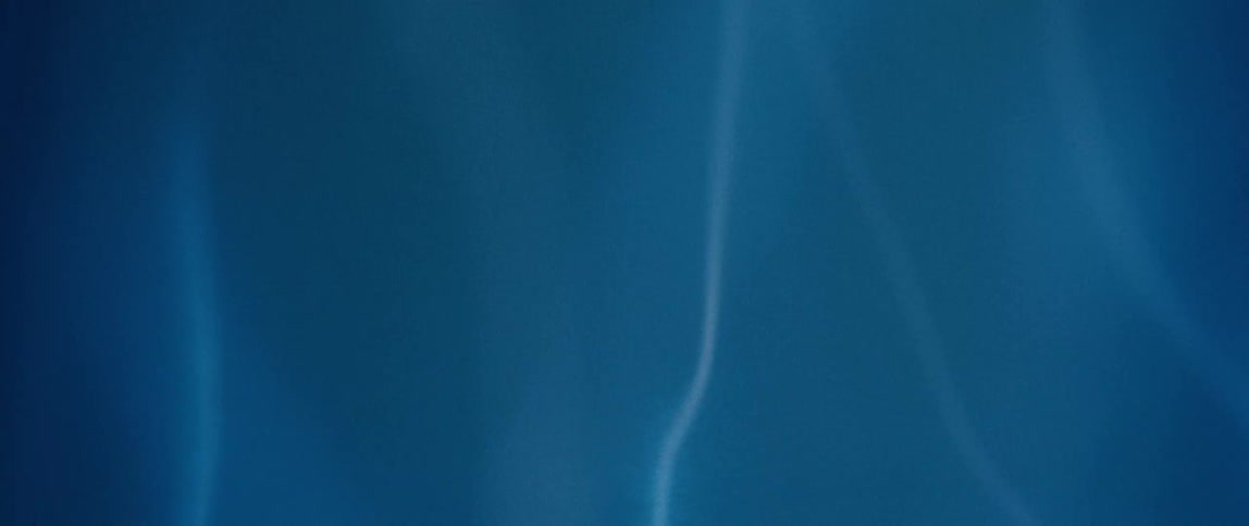Plasma bolts originating at a dark object wave against a pale blue background