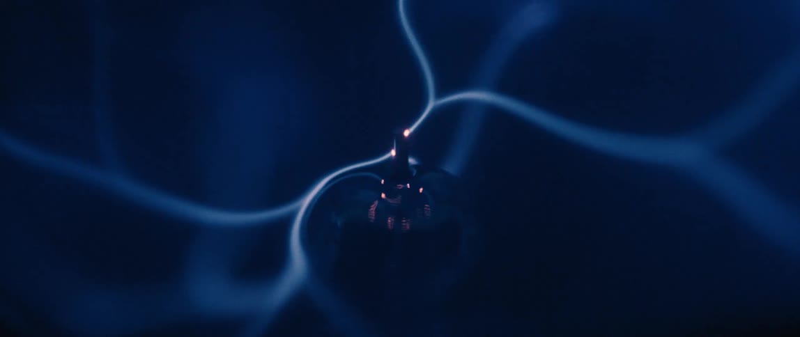 A glowing bright blue electric current flows in intricate interconnected lines across a dark background