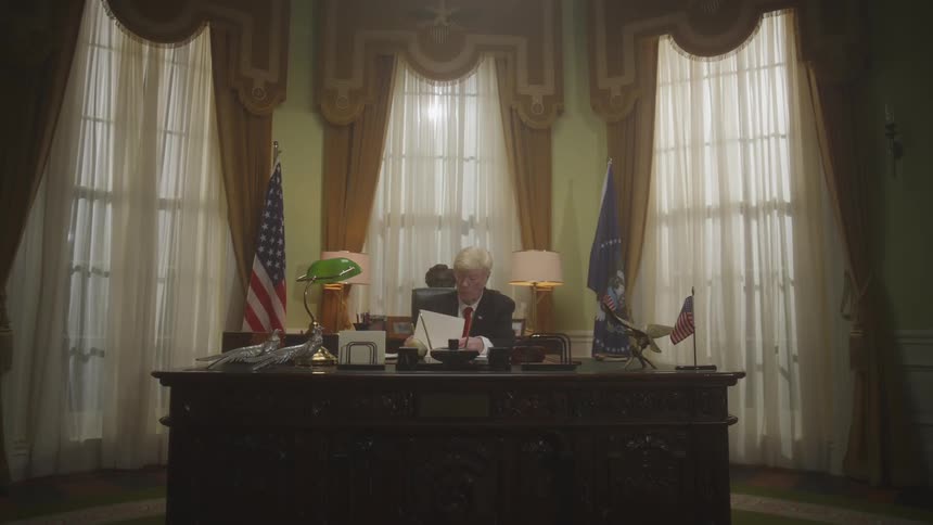 The president is writing on documents in the oval office