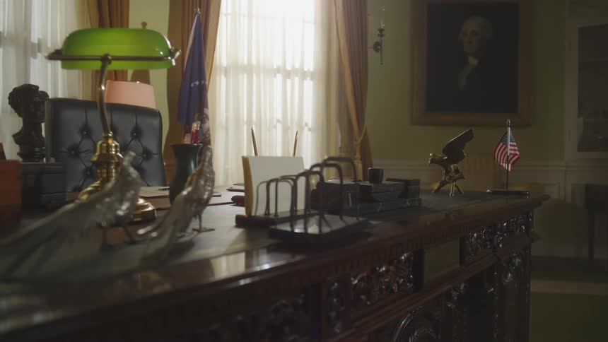 A painting of a president is on the wall in the oval office