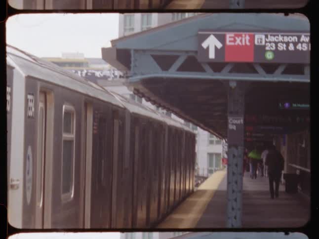 People walking at a station and a train arriving