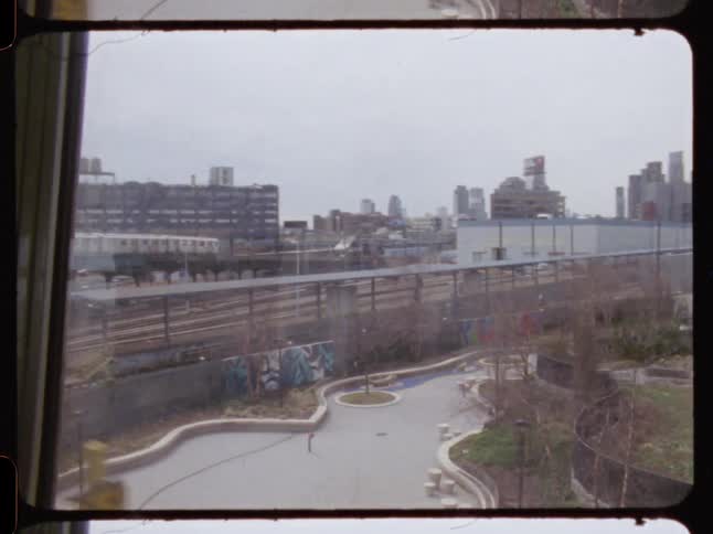 Train passes on elevated track in urban area under cloudy sky