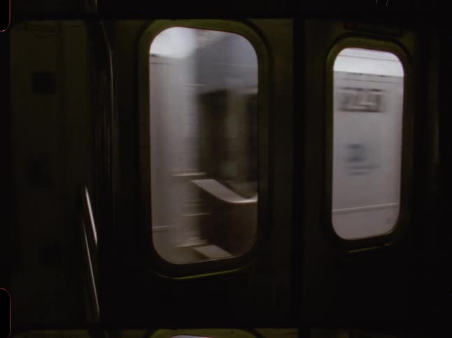 A blurred view from inside a subway car shows another train passing bysources and related content