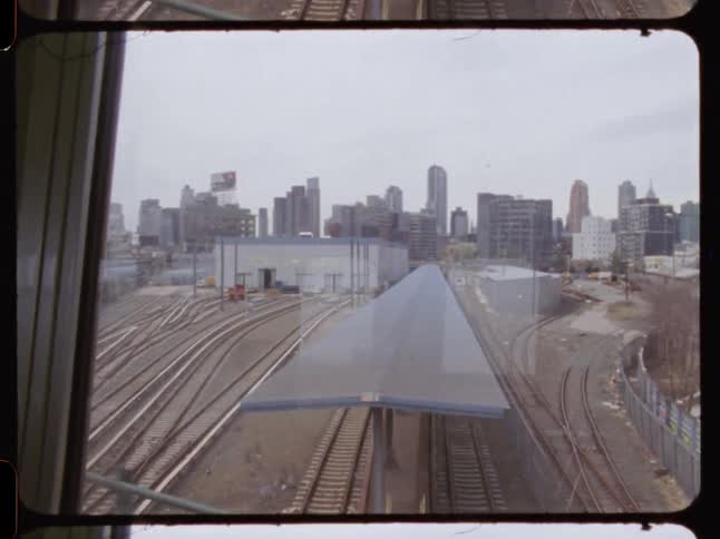 On a subway looking out the window at a city skyline