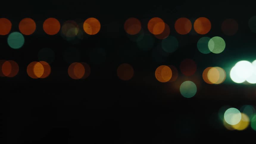 Colorful blurred bokeh lights float against a dark background