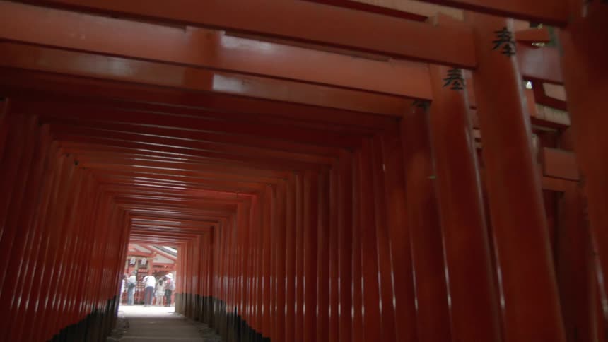 People stand at the end of an asian walkway with wooden beams