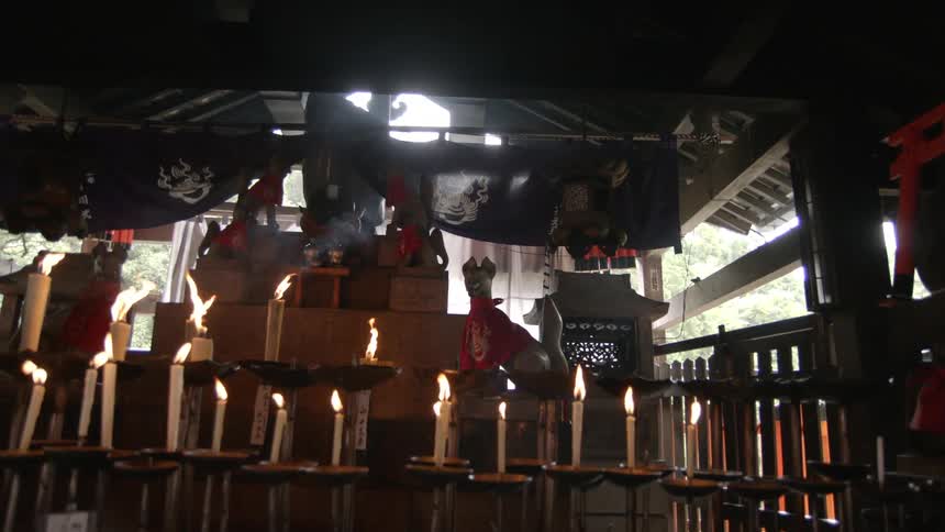 A dark room has many lit candles