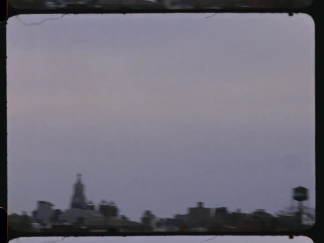 Downtown buildings stand against a brightening sky on an overcast day