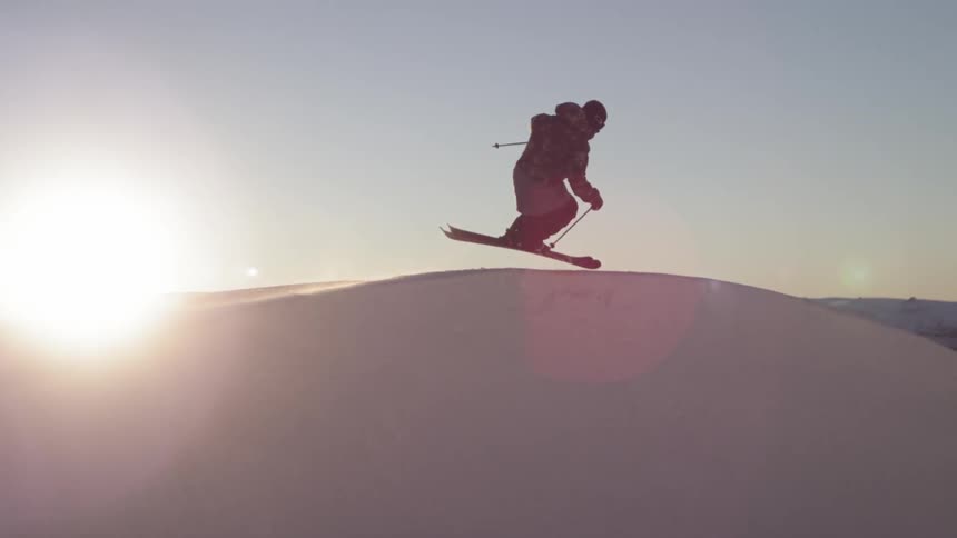 A person skiing past the sunset